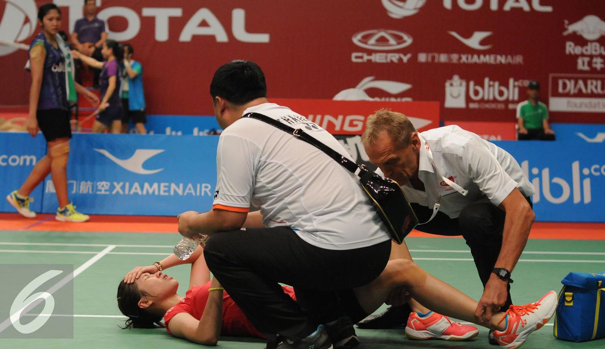 Tim medis memberikan pertolongan buat pebulutangkis Thailand, Ratchanok Intanon saat berlaga melawan Lindaweni Fanetri (Indonesia) di Total BWF Championships 2015 di Jakarta, Kamis (13/8/2015). (Liputan6.com/Helmi Fithriansyah)