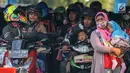 Pemudik menggendong anak sambil menanti waktu masuk kapal penyebrangan di Dermaga 1 Pelabuhan Penyebrangan Merak, Banten, Sabtu (1/6/2019). Meski berbahaya, pemudik tetap nekat membawa anak berkendara sepeda motor menuju kampong halaman. (Liputan6.com/Helmi Fithriansyah)