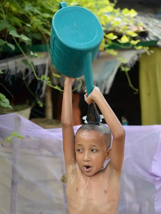 Seorang anak pengungsi Rohingya mandi di kamp Kutupalong, di Ukhia, Bangladesh pada 6 Oktober 2020. Lebih dari satu juta etnis Rohingya melarikan diri dari Myanmar dan menetap di Kutupalong yang merupakan salah satu kamp pengungsi terbesar di dunia. (Munir Uz Zaman/AFP)