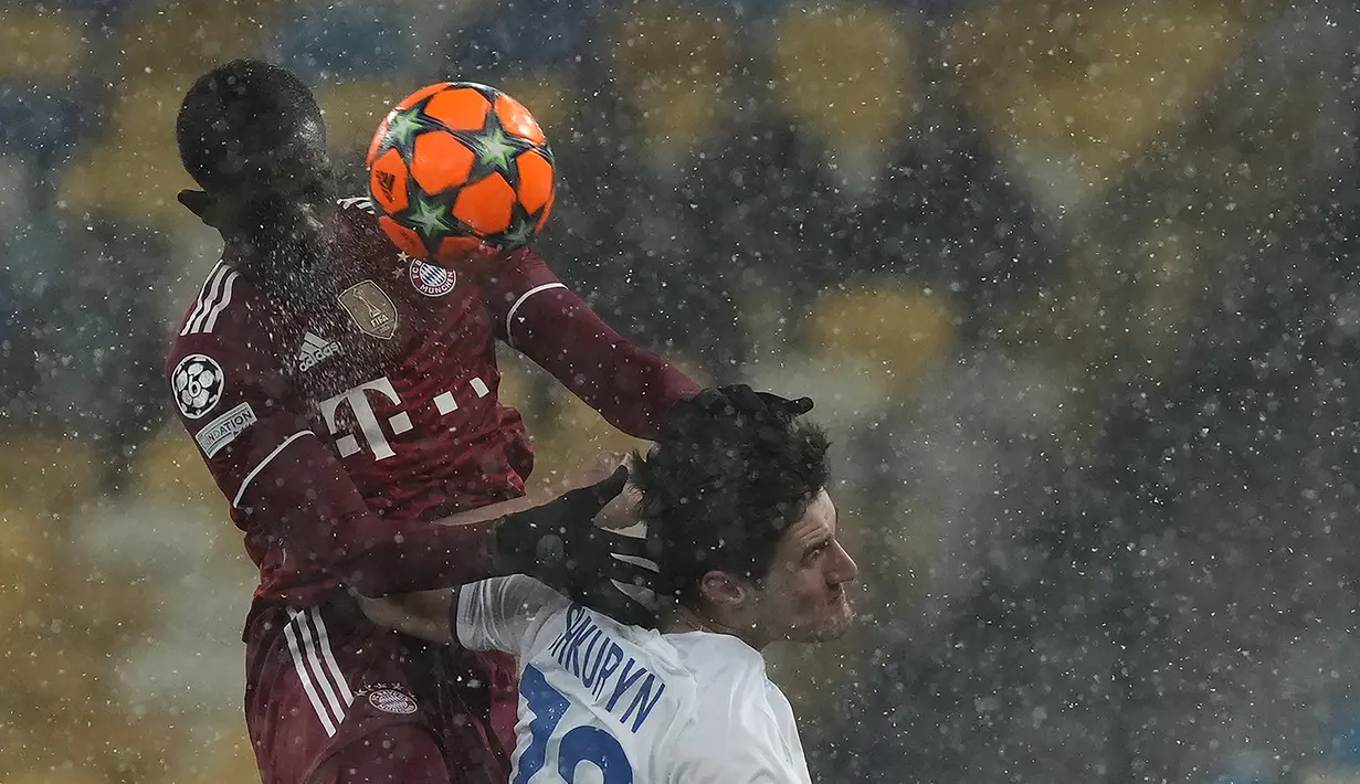 Bek Bayern Munchen Tanguy Nianzou berebut bola dengan penyerang Dynamo Kiev  Ilya Shkurin pada matchday kelima Grup E Liga Champions di NSC Olympiyskiy, Rabu (24/11/2021). Bayern Munchen menang tipis saat bertamu ke markas Dynamo Kiev dengan skor 2-1. (AP Photo/Efrem Lukatsky)
