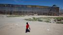 Seorang anak melihat pekerja dari Amerika Serikat saat membangun dinding perbatasan AS-Meksiko di Sunland Park, AS (09/9). Amerika Serikat dan Mexico merupakan dua negara yang memiliki batas geografis yang berdekatan. (REUTERS/Jose Luis Gonzalez)