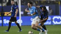 Khvicha Kvaratskhelia dari Napoli, kiri, didorong oleh Hakan Calhanoglu dari Inter Milan, kanan, saat pertandingan sepak bola final Piala Super Italia antara Inter Milan dan Napoli di Stadion Al Awwal Park di Riyadh, Arab Saudi, Senin, 22 Januari 2024. (AP Foto)