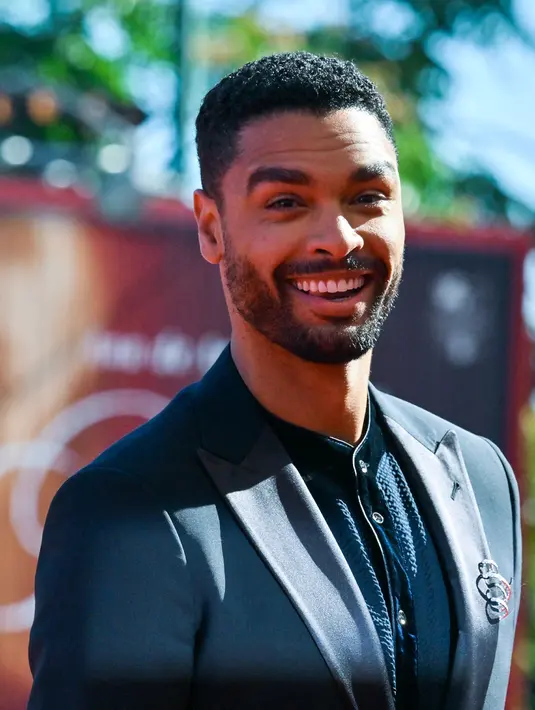 <p>Aktor Inggris Rege-Jean Page tiba untuk pemutaran film 'The Banshees of Inisherin' pada acara Venice International Film Festival ke-79 di Lido, Venesia, Italia, 5 September 2022. Rege-Jean Page menambahkan detail bros logam pada jasnya. (Andreas SOLARO/AFP)</p>