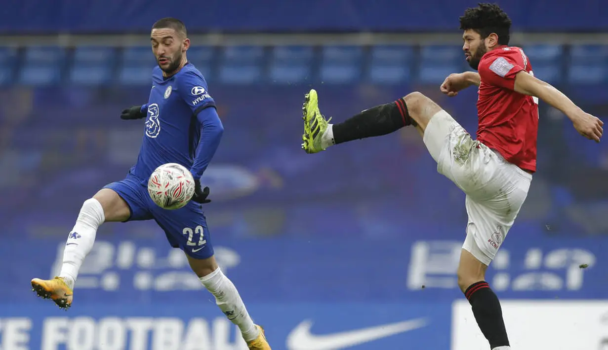 Pemain Chelsea, Hakim Ziyech, berebut bola dengan pemain Morecambe, Nathaniel Knight-Percival, pada laga Piala FA di Stadion Stamford Bridge, Minggu (10/1/2021). Chelsea menang dengan skor 4-0. (AP/Matt Dunham)