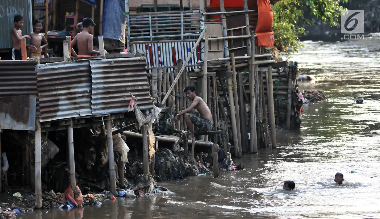 Anak-anak berenang di bawah jamban yang berada di bantaran Kali Ciliwung, Jakarta, Senin (19/11). Saat ini, tercatat sekitar 500 ribu penduduk DKI Jakarta tidak memiliki akses sanitasi yang layak. (Merdeka.com/Iqbal Nugroho)