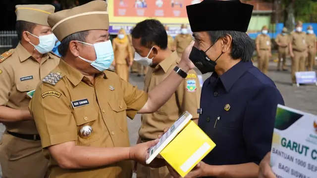 Bupati Rduy tengah memberikan bantuan sebesar Rp15 juta, sebagai uang pembinaan untuk Juara STQ (Seleksi Tilawatik Qur’an) tingkat Provinsi Jawa Barat via program Garut Taqwa.
