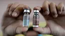 Perawat menunjukkan botol vaksin anti-dengue di Sekolah Dasar Parang di Marikina, sebelah barat Manila, Senin (4/4). Filipina telah melancarkan vaksin pertama di dunia untuk penyakit Demam Berdarah Dengue (DBD) itu kepada 1 juta pelajar. (NOEL CELIS/AFP)
