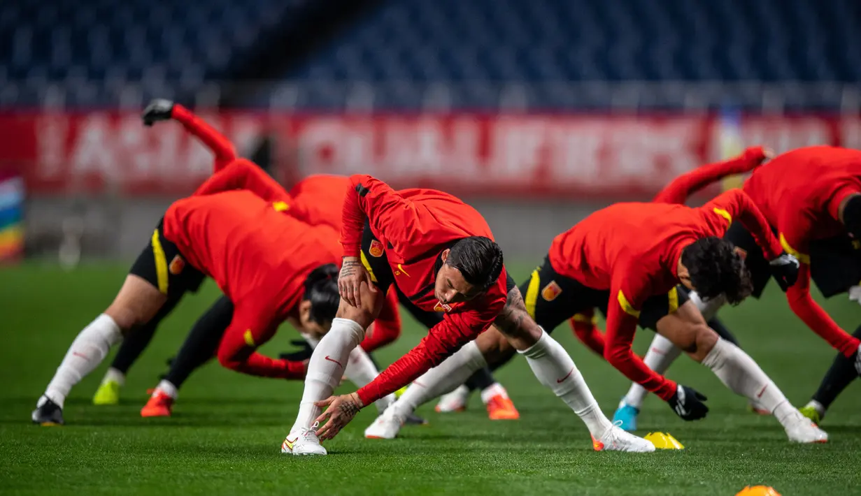 Para pemain China melakukan pemanasan saat mengikuti sesi latihan di Stadion Saitama, Jepang, Rabu (26/1/2022). China akan menghadapi Jepang pada Kualifikasi Piala Dunia 2022 Grup B Zona AFC. (AFP/Philip Fong)