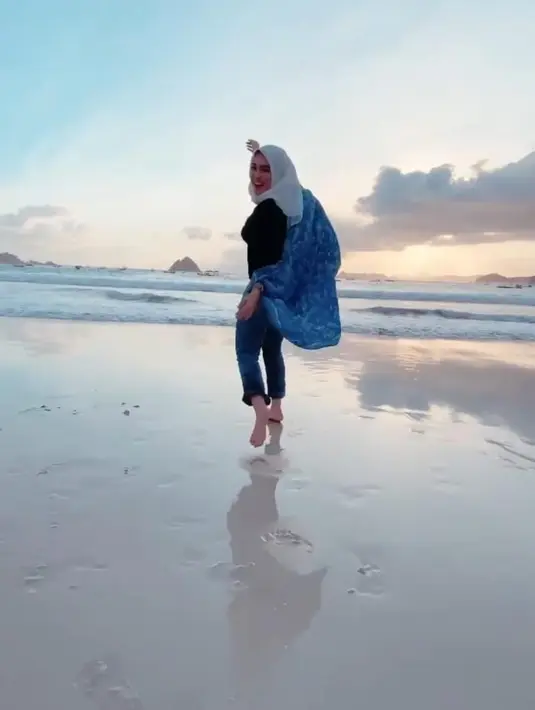 Nabilah Ayu tampil sederhana dengan inner hitam yang dipadukand engan outer bermotif biru dan celana jeans. Dia pun terlihat bahagia saat sedang menikmati keindahan alam. [instagram/nblh.ayu]