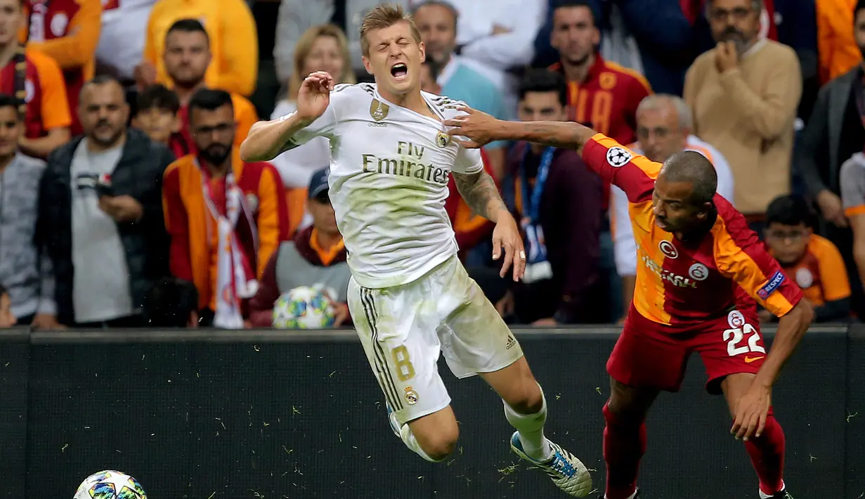 Pemain Real Madrid Toni Kroos (kiri) duel dengan pemain Galatasaray Mariano Ferreira saat bertanding pada laga Liga Champions di Istanbul, Turki, Selasa (22/10/2019). Real Madrid mengalahkan Galatasaray lewat gol tunggal Toni Kroos. (AP Photo)