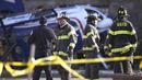 Petugas pemadam kebakaran berkumpul di tempat kejadian setelah sebuah helikopter medis jatuh di dekat Gereja Drexel Hill United Methodist Church di Drexel Hill, Philadelphia, Pennsylvania, AS (11/1/2022). (Monica Herndon/The Philadelphia Inquirer via AP)