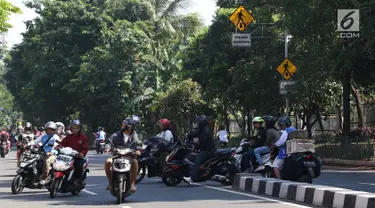 Sejumlah pengendara sepeda motor memutar balik dan melawan arus di kawasan Jagakarsa, Jakarta, Minggu (6/1). Jauhnya akses putar balik menyebabkan para pemotor nekat melawan arah, meskipun berbahaya bagi keselamatan. (Liputan6.com/Immanuel Antonius)