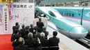 Warga saat menyambut dengan meriah kereta peluru Shinkansen tujuan Shin-hakodate-Hokuto di stasiun Tokyo, Sabtu (26/3). Dengan adanya jalur baru kereta supercepat ini perjalanan Tokyo-Hokkaido ditempuh hanya selama 4 jam 2 menit. (JIJI PRESS / AFP)