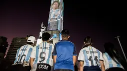 Video mapping memperlihatkan gambar bintang sepak bola Argentina Lionel Messi dan Angel Di Maria di "Monumento Nacional a la Bandera" di Rosario, Senin (21/11/2022). Proyeksi tersebut mengulas gambar Messi di berbagai Piala Dunia yang dimainkan dari tahun 2006 hingga sekarang. (Marcelo Manera / AFP)