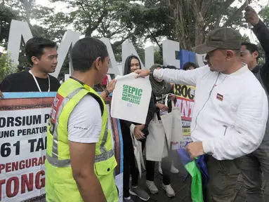 Wali Kota Bogor Bima Arya Sugiarto mensosialisasikan pengurangan penggunaan kantong plastik di Sempur, Bogor, Jawa Barat, Minggu (25/11). Bima Arya mengeluarkan Peraturan Wali Kota Nomor 61 Tahun 2018. (Merdeka.com/Arie Basuki)