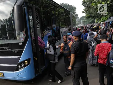 Masyarakat menaiki bus Transjakarta di depan Cibubur Junction, Jakarta, Senin (16/4). Imbas penerapan penerapan Ganjil-Genap di ruas Gerbang Tol Cibubur 2 sebagaian masyarakat memilih menggunakan Transjakarta. (Liputan6.com/Faizal Fanani)