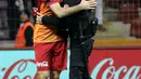 Pemain Galatasaray, Yasin Oztekin memeluk petugas polisi setelah mencetak gol saat melawan Gaziantepspor dalam Liga Super Turki di Istanbul, Minggu (11/12). Itu dilakukan Oztekin sebagai ungkapan duka cita atas tragedi ledakan bom Besiktas (AFP PHOTO/STR)