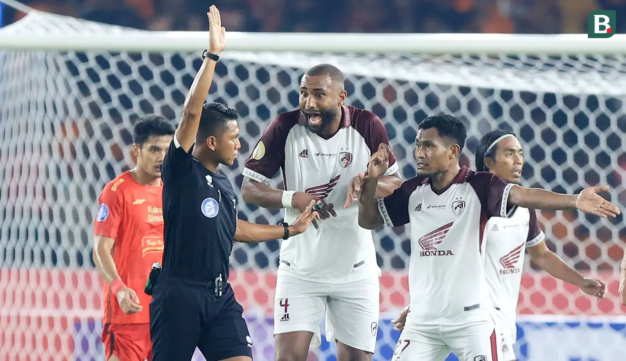 <p>Dua pemain PSM Makassar, Yuran Lopes (tengah) dan Safrudin Tahar memprotes keputusan wasit pada laga pekan pertama BRI Liga 1 2023/2024 antara Persija Jakarta menghadapi PSM Makassar di Stadion Utama Gelora Bung Karno (SUGBK), Senayan, Jakarta, Senin (3/7/2023). (Bola.com/M Iqbal Ichsan)</p>
