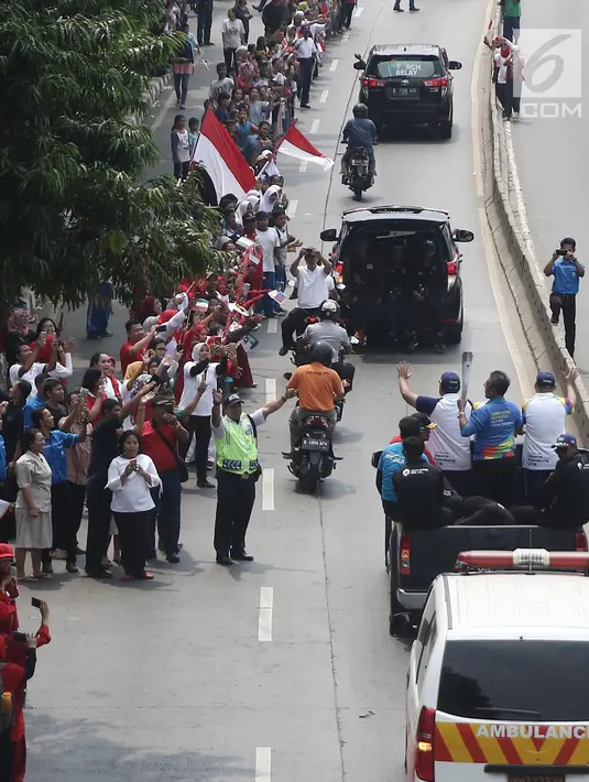 Masyarakat menyambut kedatangan Torch Relay Asian Games 2018 di kawasan Slipi, Jakarta, Kamis (16/08). Obor Asian Games 2018 tiba di wilayah Jakarta Barat  dan nantinya akan di teruskan berkeliling Jakarta Utara.(Liputan6.com/  Herman Zakharia)