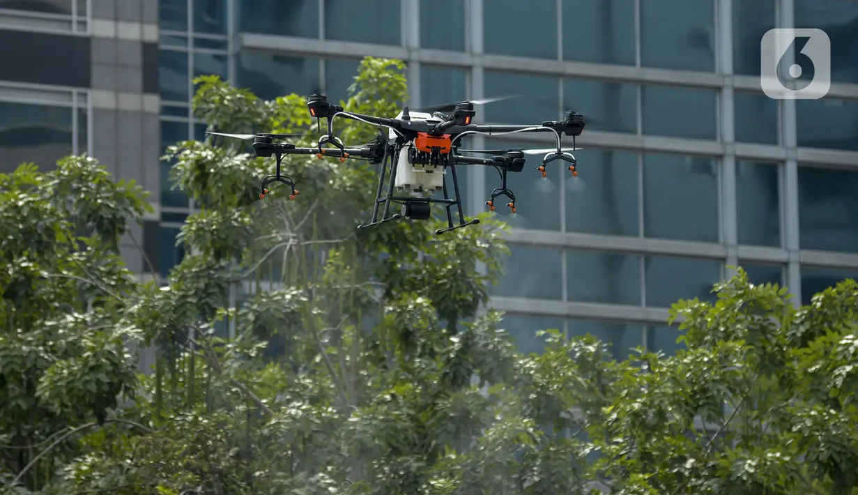 Drone menyemprotkan cairan disinfektan di Jalan Bursa Efek menuju Patung  Pemuda, Jakarta, Jumat (27/3/2020). Penyemprotan dilakukan untuk mencegah penyebaran virus corona COVID-19. (merdeka.com/Imam Buhori)