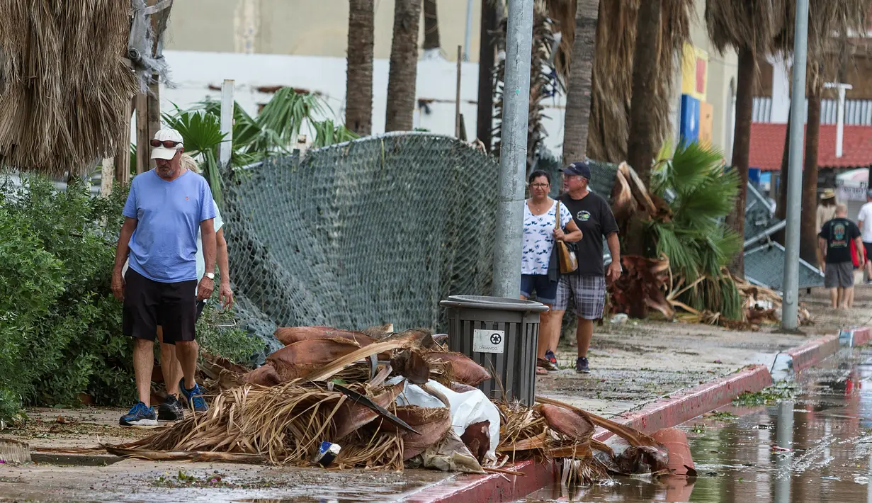 Wisatawan berjalan melewati sisa-sisa hantaman Badai Newton di Los Cabos, Meksiko, Selasa (6/9). Menurut otoritas berwenang, Badai Newton telah mengakibatkan dua orang meninggal dan tiga lainnya hilang. (REUTERS/Fernando Castillo)