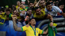 Striker Timnas Brasil, Gabriel Jesus berpose bersama penggemar saat merayakan gelar juara Copa America 2019 setelah mengalahkan Peru pada partai final di Maracana Stadium, Senin (8/7/2019) dini hari WIB. Brasil sukses mengangkat trofi Copa America 2019 usai mengalahkan Peru 3-1. (Juan MABROMATA/AFP)
