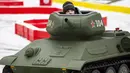 Seorang anak laki-laki mengendarai model tank T-34 era Soviet yang legendaris di objek wisata petualangan anak-anak Tankodrom di taman Sokolniki di Moskow, Rusia (6/1/2020). Model tank ini memiliki mesin pembakaran internal dan kontrol seperti aslinya. (AP Photo/Alexander Zemlianichenko)