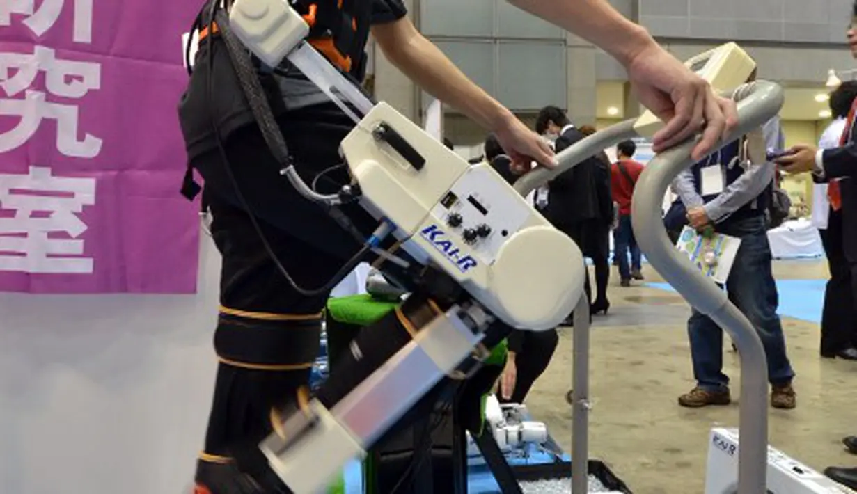 Seorang pengunjung sedang mencoba robot yang bisa melakukan terapi untuk kaki yang patah di Japan Robot Week 2014, Tokyo, Rabu (15/10/2014) (AFP PHOTO/Yoshikazu Tsuno)
