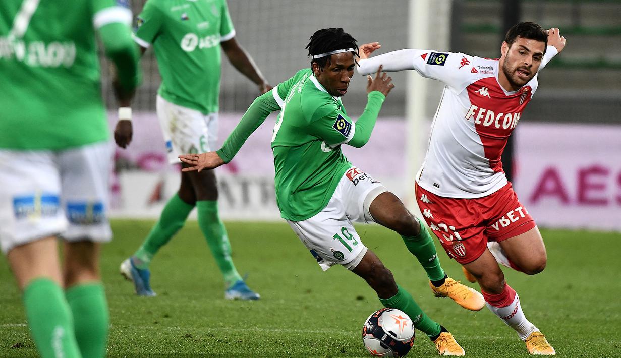 Gelandang Saint-Etienne, Yvan Neyou (kiri) berebut bola dengan striker AS Monaco, Kevin Volland dalam laga lanjutan Liga Prancis 2020/2021 pekan ke-30 di Geoffroy Guichard Stadium, Jumat (19/3/2021). Saint-Etienne kalah 0-4 dari Monaco. (AFP/Jeff Pachoud)
