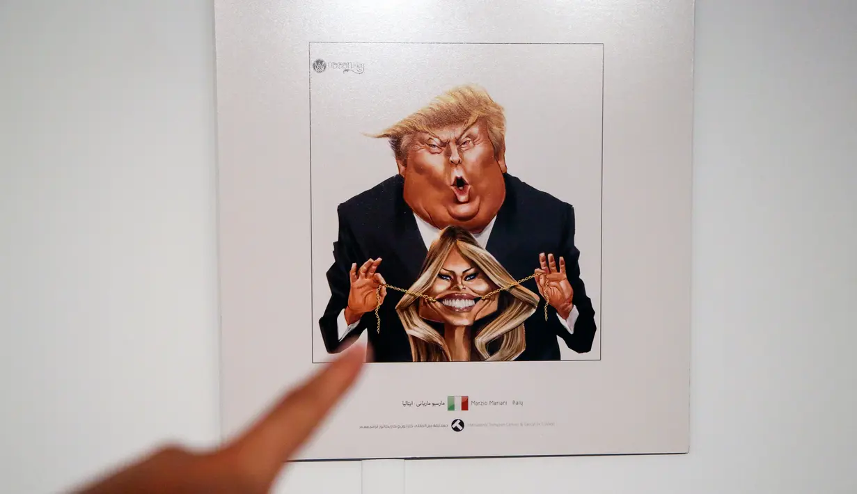 Sebuah kartun Presiden AS Donald J. Trump dan Ibu Negara Melania Trump yang dipajang di pameran kartun Trumpisme 2017 Internasional dan kontes karikatur, di ibukota Teheran, Iran (3/7). (AFP Photo/Atta Kenare)