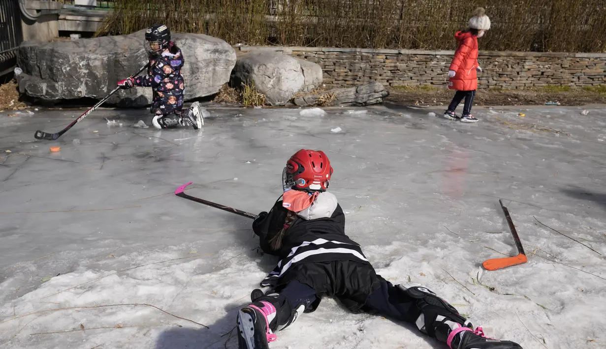 Anak-anak bermain hoki es di kanal beku saat Olimpiade Musim Dingin 2022 hampir berakhir di Beijing pada Sabtu, 19 Februari 2022. (AP Photo/Ng Han Guan)