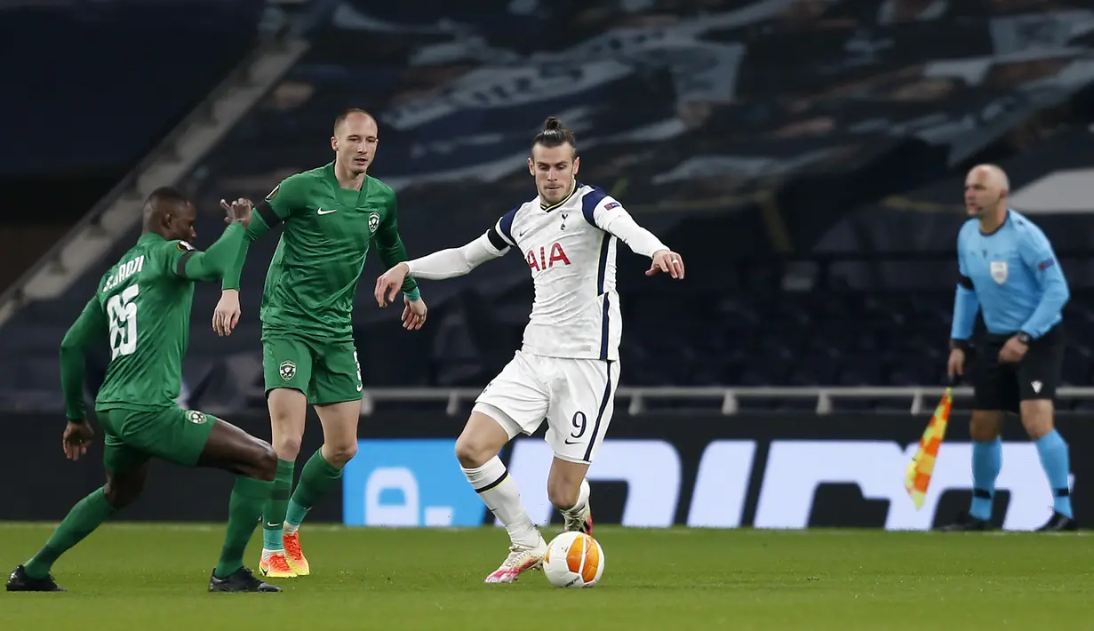 Gelandang Tottenham, Gareth Bale, berebut bola dengan gelandang Ludogorets, Stephane Badji, pada laga lanjutan Grup J Liga Europa di Tottenham Hotspur Stadium, Jumat (27/11/2020) dini hari WIB. Tottenham menang 4-0 atas Ludogorets. (AFP/Ian Kington/pool)