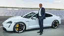CEO Porsche, Oliver Blume, berdiri di sebelah mobil elektrik Porsche, Taycan selama world premiere di bandara Neuhardenberg, dekat Berlin, Rabu (4/9/2019). Mobil listrik dengan model Saloon Sport 4 pintu itu disebut menawarkan ketangguhan namun bisa dipakai sehari-hari. (Patrick Pleul/dpa via AP)