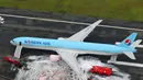 Gambar udara menunjukkan sejumlah penumpang berdiri di dekat pesawat Korean Air Lines setelah asap keluar dari bagian mesin sebelah kiri itu di bandara Haneda di Tokyo, Jepang, (27/5). (Reuters/ Kyodo)