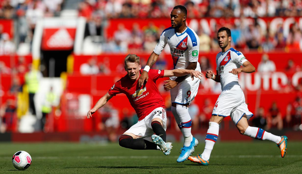 Pemain Manchester United (MU) Scott McTominay (kiri) dan pemain Crystal Palace Jordan Ayew (tengah) berebut bola saat bertanding dalam Liga Inggris di Old Trafford, Manchester, Inggris, Sabtu (24/8/2019). MU kalah dari Crystal Palace dengan skor 1-2. (AP Photo/Alastair Grant)