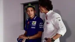 Pembalap tim Yamaha, Valentino Rossi berbicara dengan kru Dorna sebelum konferensi pers MotoGP Aragon 2017 di Sirkuit MotorLand, Spanyol, Kamis (21/9). Rossi akan ambil bagian pada latihan Jumat (22/9) menjelang balapan. (JAVIER SORIANO/AFP)