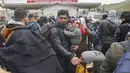 Warga Suriah menunggu untuk menyeberang ke Suriah dari Turki di gerbang perbatasan Cilvegozu, dekat kota Antakya, tenggara Turki, Selasa (21/2/2023). Tim penyelamat kembali melakukan pencarian atas orang-orang yang terperangkap di bawah reruntuhan bangunan di Turki, setelah dua gempa bumi baru melanda negara itu pada Senin 20 Februari 2023.  (AP Photo/Unal Cam)