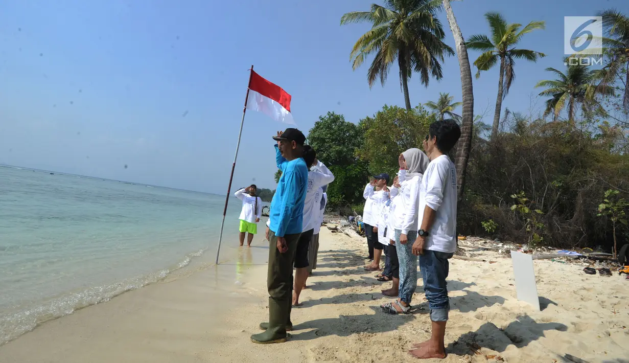 Aktivis Yayasan Kehati Jakarta  dan penjaga pulau melakukan upacara bendera menghadap laut dalam rangka HUT ke-74 RI di Pulau Sangiang, Banten, Minggu (18/8/2019). Kegiatan ini dilakukan serentak secara nasional di 73 titik untuk mencintai laut dan sumber daya alamnya. (merdeka.com/Arie Basuki)