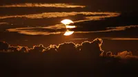 Gerhana matahari sebagian muncul di balik awan, Arbutus, Md, Kamis (10/6/2021).  (AP Photo/Julio Cortez)