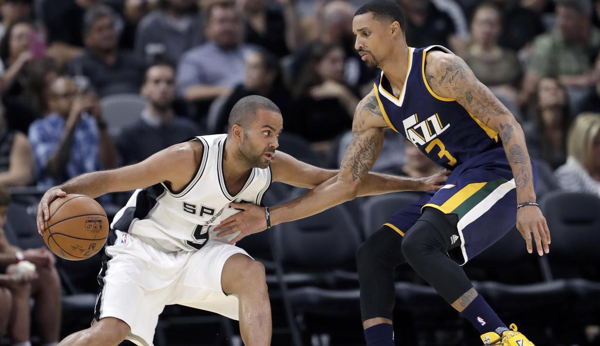 Pemain San Antonio Spurs, Tony Parker #9 berusaha melewati hadangan pemain Utah Jazz, George Hill #3 pada laga NBA basketball game di AT&T Center, San Antonio, (1/10/2016). Utah menang 106-91. (AP/Eric Gay)