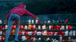 Seorang siswi meletakan lilin di depan SMA Josef-Koenig-Gymnasium sebagai tanda duka jatuhnya pesawat Germanwings, Jerman, Selasa (24/3/2015). Belasan pelajar dan guru dari sekolah itu turut menjadi penumpang pesawat Germanwings. (REUTERS/Kirsten Neumann)