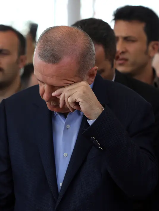 Presiden Turki Recep Tayyip Erdogan mengusap matanya saat menunaikan salat gaib untuk mantan Presiden Mesir Mohammed Morsi di Masjid Fatih, Istanbul, Selasa (18/6/2019). Erdogan diketahui memiliki kedekatan dengan Mohammed Morsi. (AP Photo/Emrah Gurel)