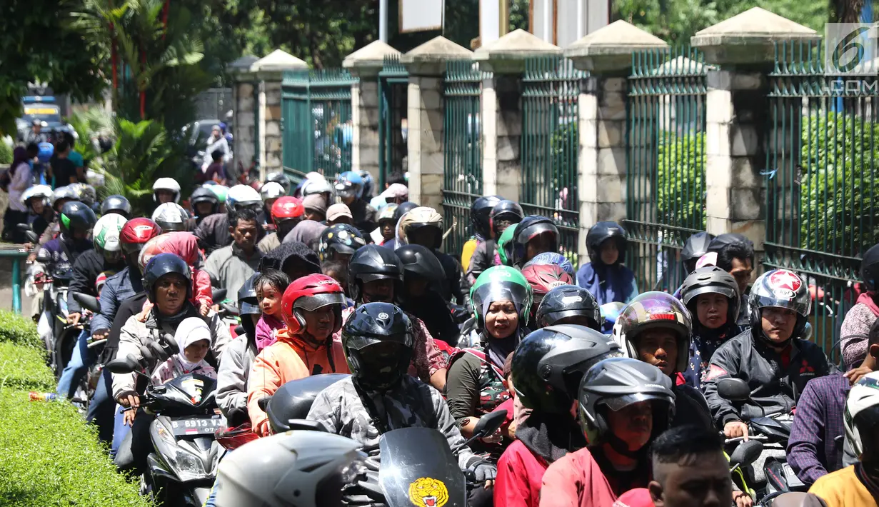 Warga memadati lajur pintu masuk area parkir motor kawasan Kebun Binatang Ragunan, Jakarta, Minggu (30/12). Libur panjang jelang pergantian tahun dimanfaatkan warga untuk berlibur di kawasan Kebun Binatang Ragunan. (Liputan6.com/Helmi Fithriansyah)