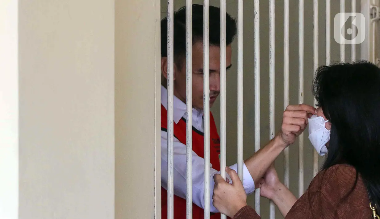 Terdakwa kasus pelanggaran UU ITE Adam Deni (kiri) berada dalam ruang tahanan Pengadilan Negeri Jakarta Utara, Selasa (7/6/2022). Adam Deni menjalani sidang lanjutan atas dugaan pelanggaran UU ITE yang beragendakan pembacaan nota pembelaan atau pledoi atas tuntutan 8 tahun penjara dari Jaksa Penuntut Umum (JPU). (Liputan6.com/Herman Zakharia)