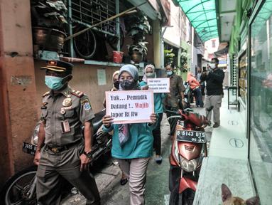 Petugas Satpol PP bersama Ibu Pembinaan Kesejahteraan Keluarga (PKK) berkeliling lingkungan membawa poster saat Operasi Yustisi di RW 01 Kelurahan Sunter Agung, Tanjung Priok, Jakarta Utara, Selasa (10/5/2022). Operasi Yustisi tersebut bertujuan mendata pendatang baru pasca Lebaran sekaligus mengimbau masyarakat untuk melengkapi dosis vaksin guna mencegah penyebaran klaster mudik. (merdeka.com/Iqbal S. Nugroho)
