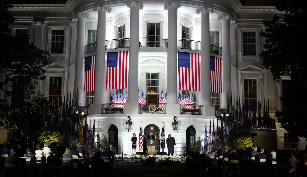 Presiden Donald Trump berbicara di hadapan Hakim Agung Clarence Thomas mengurusi Sumpah Konstitusional kepada Amy Coney Barrett setelah Barrett dipastikan menjadi hakim Mahkamah Agung di Halaman Selatan Gedung Putih Gedung Putih di Washington, Senin (26/10/2020). (AP Photo/Alex Brandon)