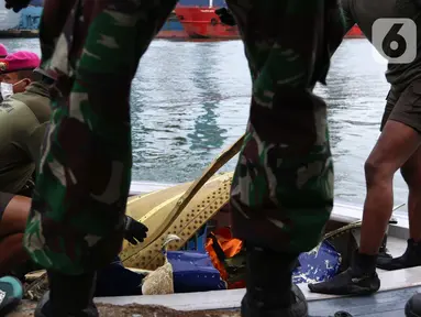 Tim selam Marinir TNI AL berhasil menemukan dan mengevakuasi serpihan pesawat Sriwijaya Air SJ 182 yang kemudian diserahkan ke Basarnas, Kepolisian, serta KNKT di Dermaga JICT 2, Jakarta, Minggu (10/1/2021). (Liputan6.com/Helmi Fithriansyah)