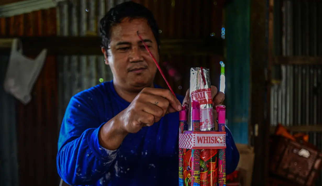 Pekerja menyelesaikan pembuatan petasan di sebuah pabrik di Bocaue, Bulacan, Filipina, Jumat (27/12/2019). Petasan-petasan tersebut akan dijual untuk perayaan Tahun Baru 2020. (Maria TAN/AFP)