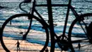 Orang-orang menjadi siluet oleh matahari terbenam di pantai yang hampir sepi selama penguncian nasional selama tiga minggu untuk mengekang penyebaran virus corona di pantai Laut Mediterania, Tel Aviv, Israel, Senin (21/9/2020). (AP Photo/Oded Balilty)
