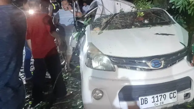 Kondisi mobil milik Parasli Bela yang rusak berat akibat tertimpa pohon tumbang di jalur Manado – Tomohon, Jumat (7/3/2025).